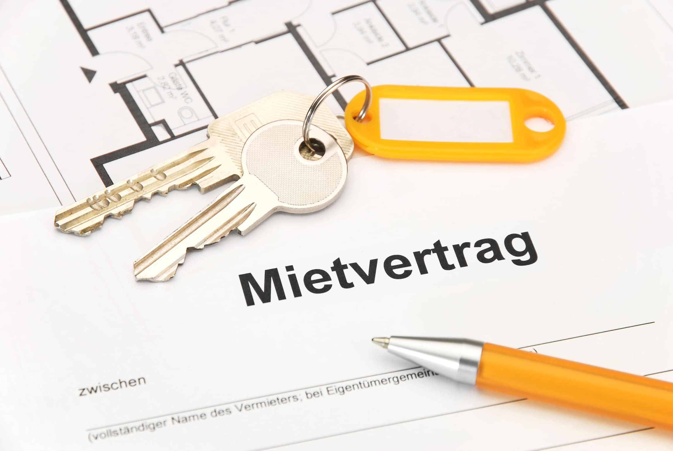 Hausschlüssel auf einem Mietvertrag – JACORA Immobilien